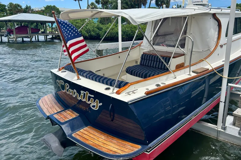 Clarity Yacht Photos Pics 2006 Hinckley 36 EP Picnic Boat docked, featuring American flag and striped seating.