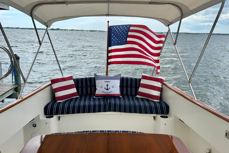 Clarity Yacht Photos Pics Hinckley 36 EP Picnic Boat, 2006, with American flag and striped seating on deck.