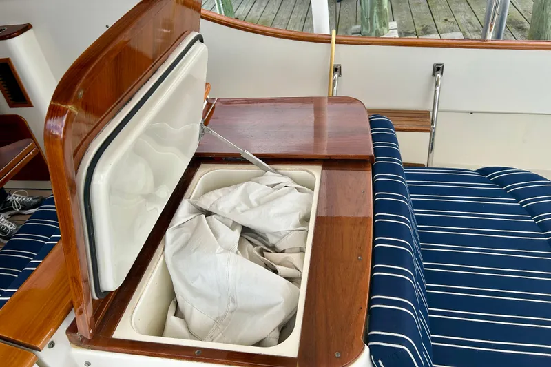 Clarity Yacht Photos Pics Storage compartment on 2006 Hinckley 36 EP Picnic Boat with striped seating and wooden accents.