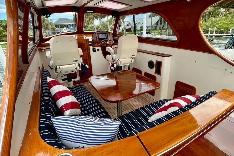 Clarity Yacht Photos Pics Luxurious 2006 Hinckley 36 EP Picnic Boat interior with striped cushions and polished wood finishes.
