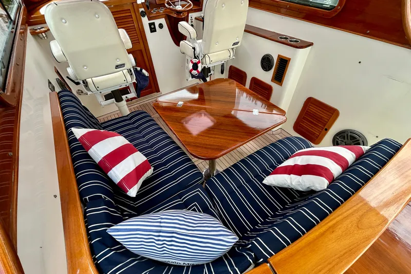 Clarity Yacht Photos Pics Interior of 2006 Hinckley 36 EP Picnic Boat with striped cushions and wooden table.