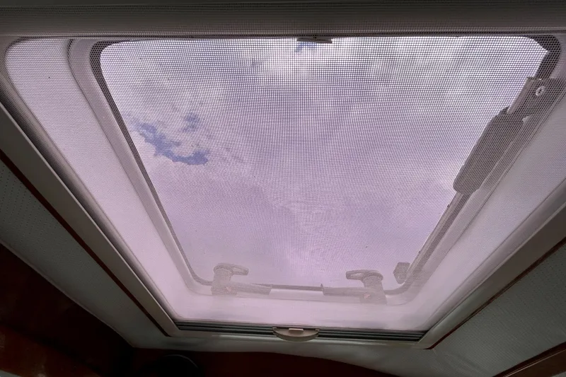 Clarity Yacht Photos Pics Hatch view from 2006 Hinckley 36 EP Picnic Boat, showcasing sky through mesh screen.