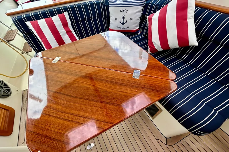 Clarity Yacht Photos Pics Elegant seating area on 2006 Hinckley 36 EP Picnic Boat with striped cushions and wooden table.