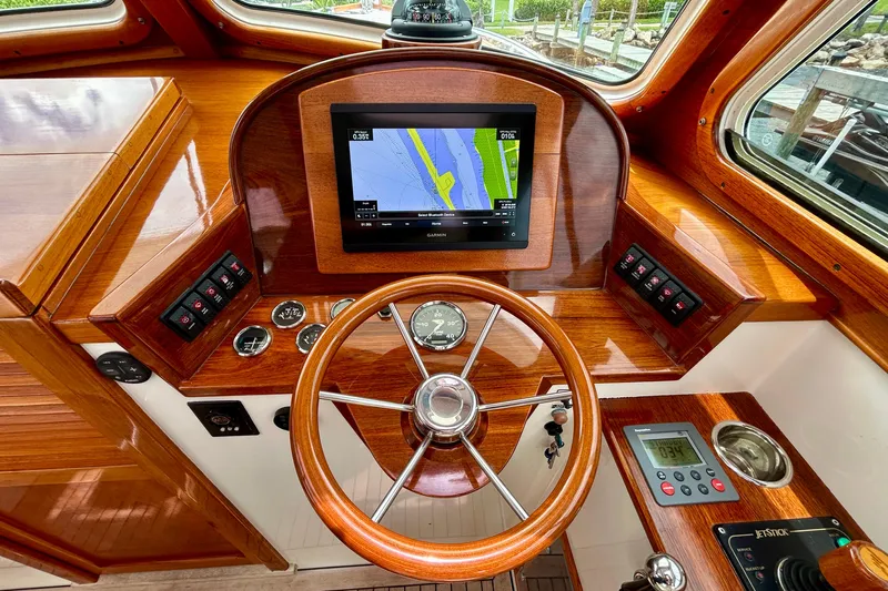 Clarity Yacht Photos Pics 2006 Hinckley 36 EP Picnic Boat helm with GPS, wooden dashboard, and steering wheel.