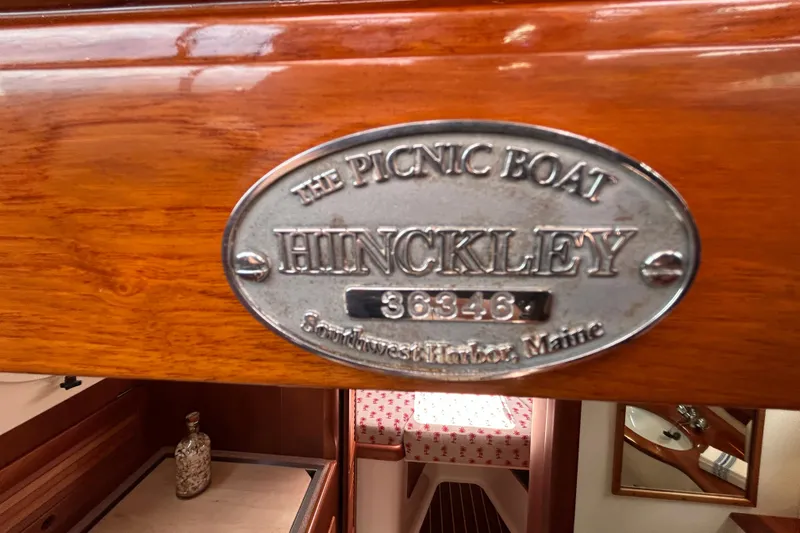 Clarity Yacht Photos Pics 2006 Hinckley 36 EP Picnic Boat interior with nameplate, wooden finish, and cozy cabin view.