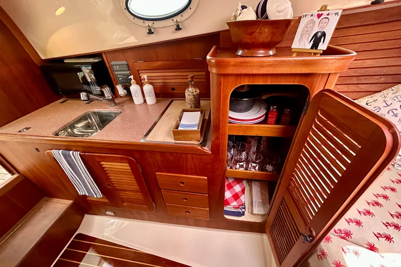 Clarity Yacht Photos Pics 2006 Hinckley 36 EP Picnic Boat interior with wooden cabinetry and kitchenette.