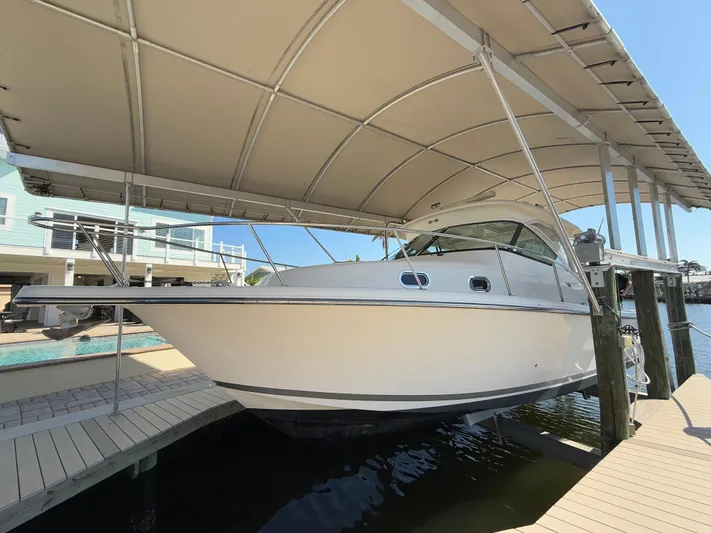  Yacht Photos Pics 2011 Pursuit OS 345 Offshore boat docked under a canopy.