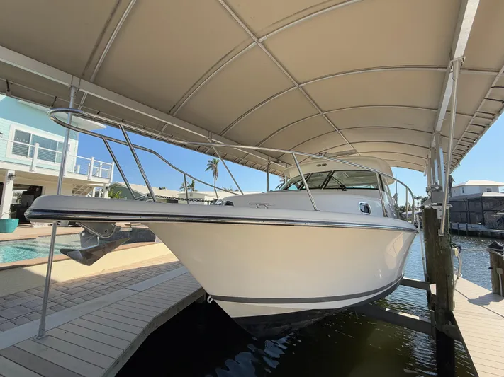  Yacht Photos Pics 2011 Pursuit OS 345 Offshore boat docked under a canopy.