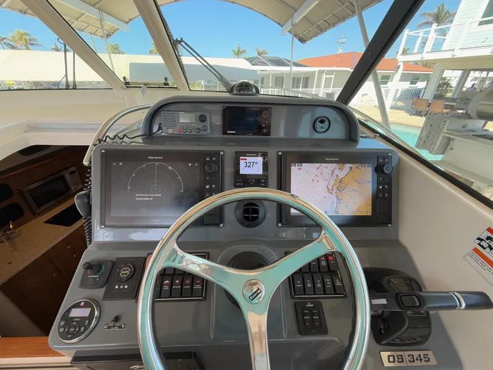  Yacht Photos Pics 2011 Pursuit OS 345 Offshore boat dashboard with navigation screens and steering wheel.