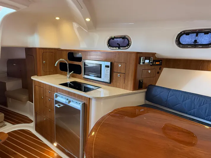  Yacht Photos Pics 2011 Pursuit OS 345 Offshore yacht interior with kitchen, microwave, and seating area.