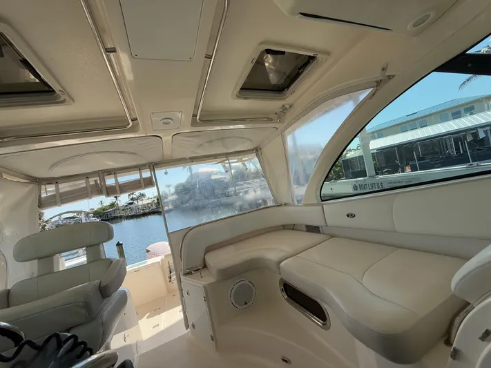  Yacht Photos Pics 2011 Pursuit OS 345 Offshore boat interior with seating and windows, docked by the water.