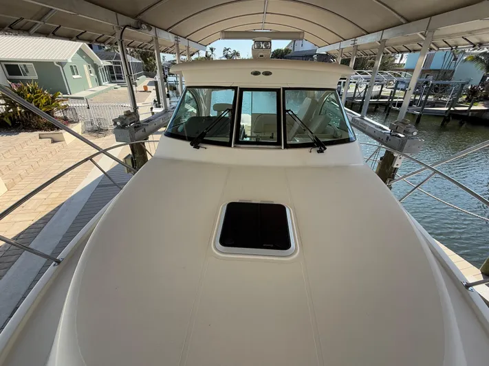  Yacht Photos Pics 2011 Pursuit OS 345 Offshore boat docked under a canopy.