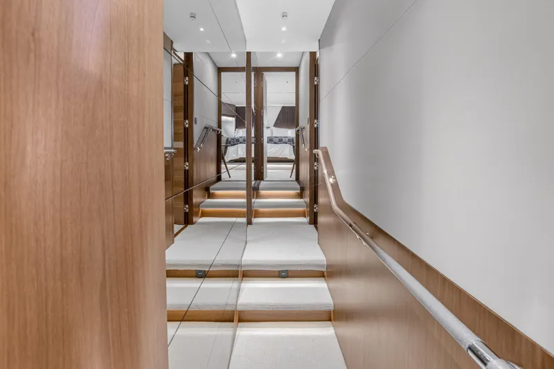  Yacht Photos Pics Luxurious interior staircase of 2022 Princess Y85 yacht, featuring sleek wood paneling and modern design.
