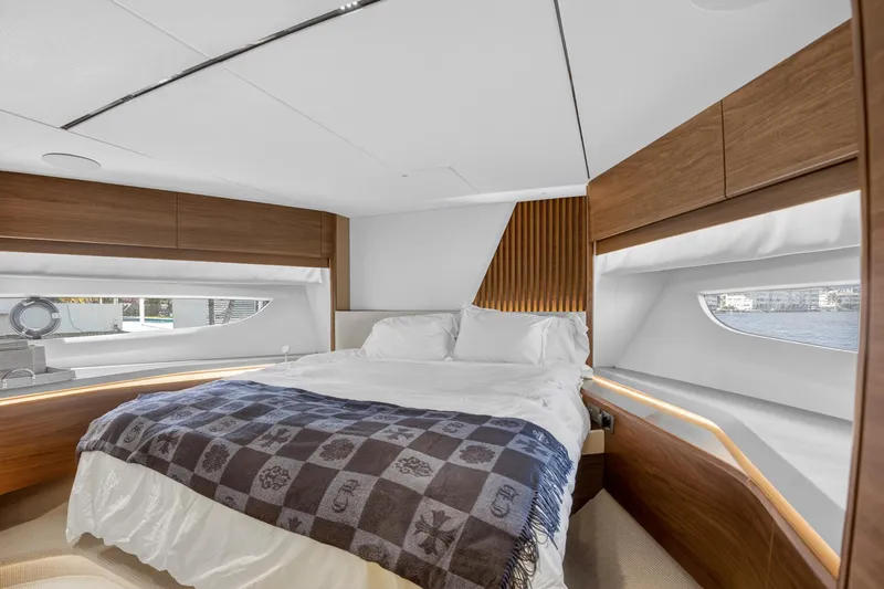  Yacht Photos Pics Luxurious bedroom interior of 2022 Princess Y85 yacht with modern wood accents.