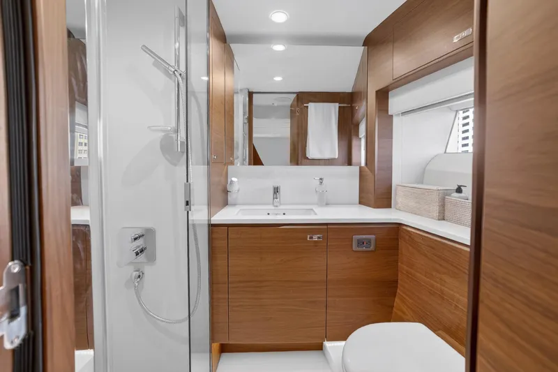  Yacht Photos Pics Luxurious 2022 Princess Y85 yacht bathroom with modern wood cabinetry and sleek fixtures.