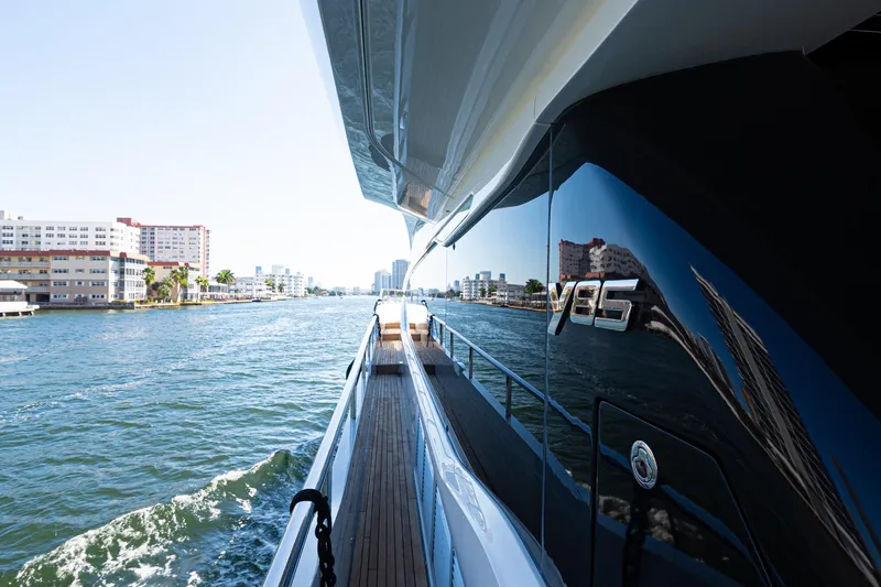  Yacht Photos Pics Luxurious 2022 Princess Y85 yacht cruising along a scenic waterfront.