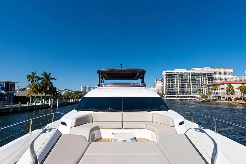  Yacht Photos Pics Luxurious 2022 Princess Y85 yacht cruising near waterfront cityscape under clear blue sky.