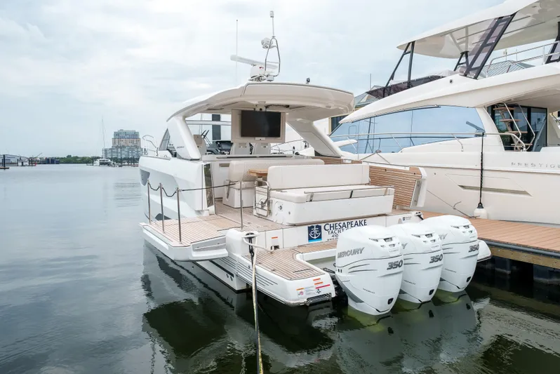  Yacht Photos Pics 2024 Jeanneau DB43 Outboard boat docked with triple engines, rear view.