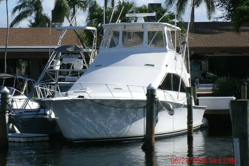  Yacht Photos Pics 1998 Ocean Yachts 48 Super Sport docked, surrounded by palm trees and calm water.