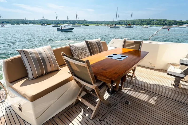 Passion Play Yacht Photos Pics Luxurious 2014 Prestige Yachts 550 Flybridge deck with seating and table, overlooking serene waters.