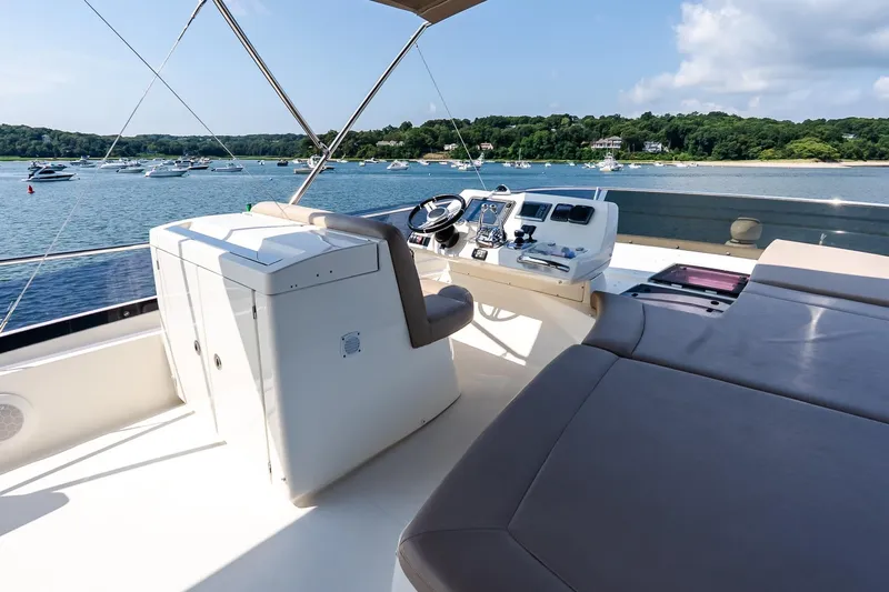 Passion Play Yacht Photos Pics Flybridge of 2014 Prestige Yachts 550, overlooking serene waters and distant boats.