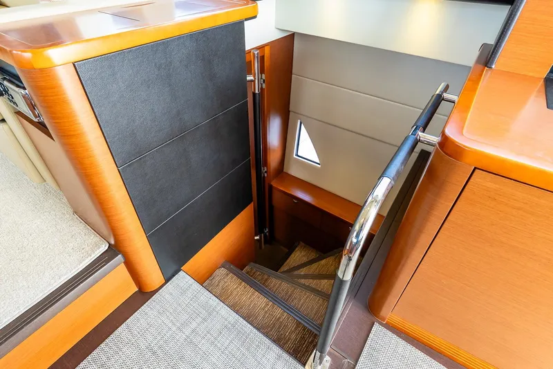 Passion Play Yacht Photos Pics Interior staircase of 2014 Prestige Yachts 550 Flybridge, featuring elegant wood finish.