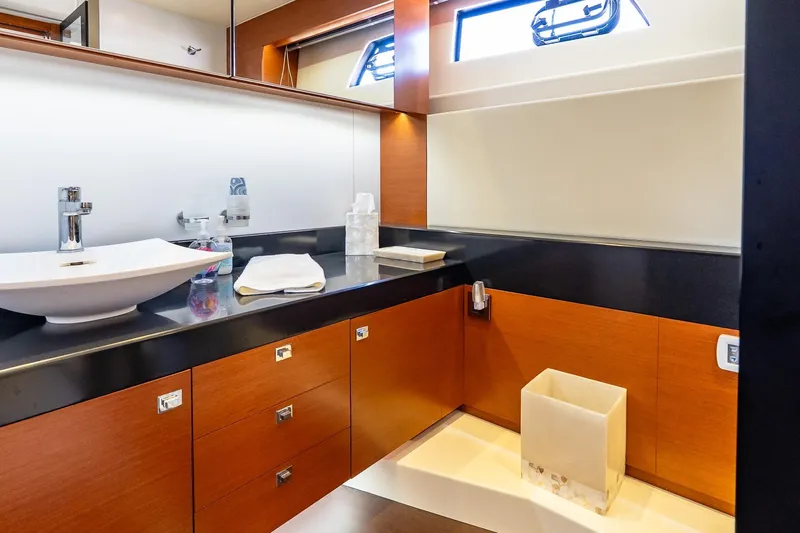 Passion Play Yacht Photos Pics Luxurious bathroom in 2014 Prestige Yachts 550 Flybridge, featuring modern sink and wooden cabinetry.