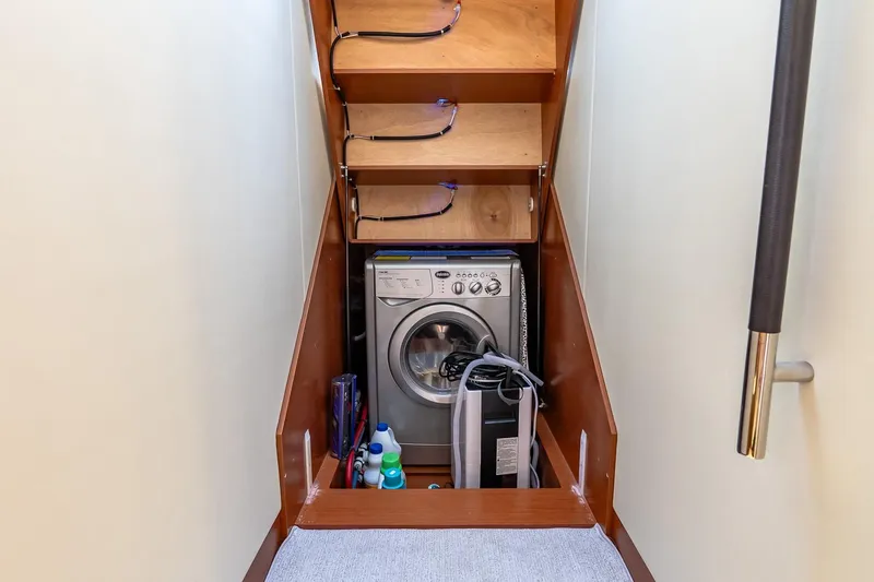 Passion Play Yacht Photos Pics Laundry area on 2014 Prestige Yachts 550 Flybridge with washing machine and storage shelves.