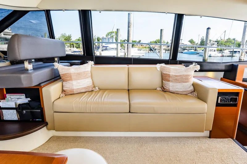 Passion Play Yacht Photos Pics Luxurious interior of 2014 Prestige Yachts 550 Flybridge with beige sofa and decorative pillows.