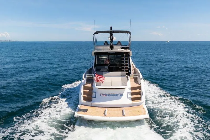  Yacht Photos Pics 2023 Sunseeker 65 Sport Yacht cruising on open sea, rear view.