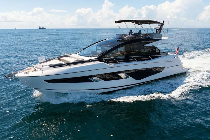  Yacht Photos Pics 2023 Sunseeker 65 Sport Yacht cruising on open water under clear skies.