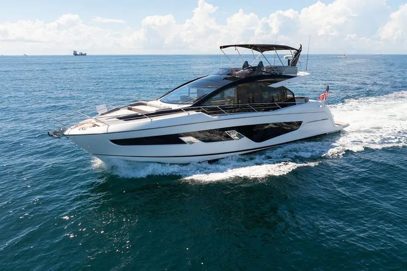  Yacht Photos Pics 2023 Sunseeker 65 Sport Yacht cruising on open sea under clear skies.