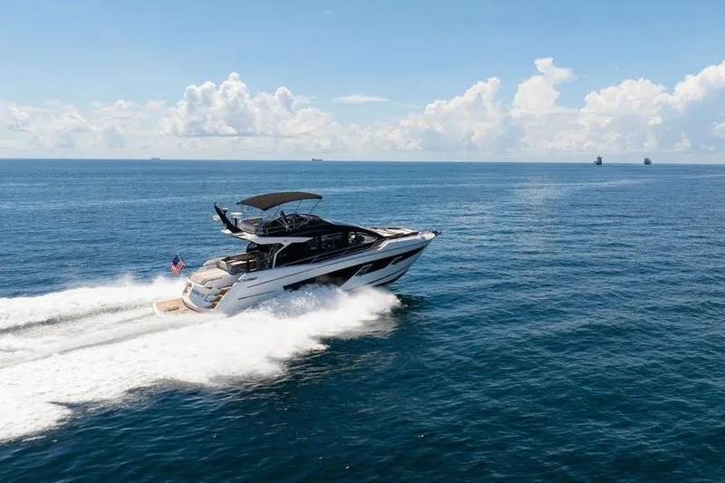  Yacht Photos Pics 2023 Sunseeker 65 Sport Yacht cruising on open sea under clear skies.