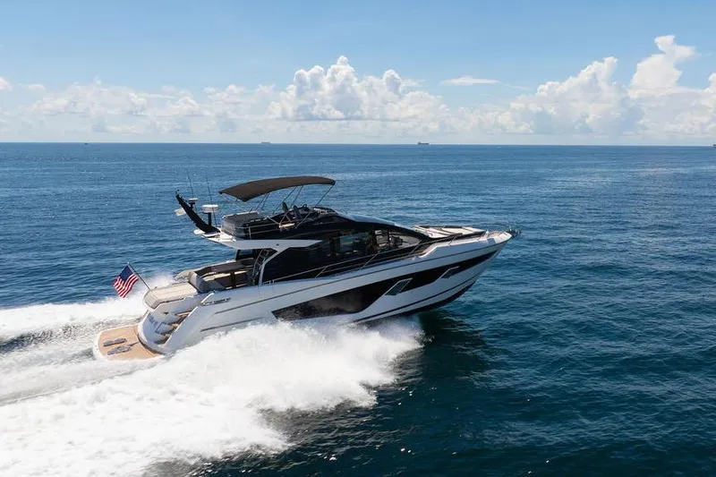  Yacht Photos Pics 2023 Sunseeker 65 Sport Yacht cruising on open sea under clear skies.