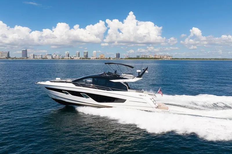  Yacht Photos Pics 2023 Sunseeker 65 Sport Yacht cruising on open water under a clear blue sky.