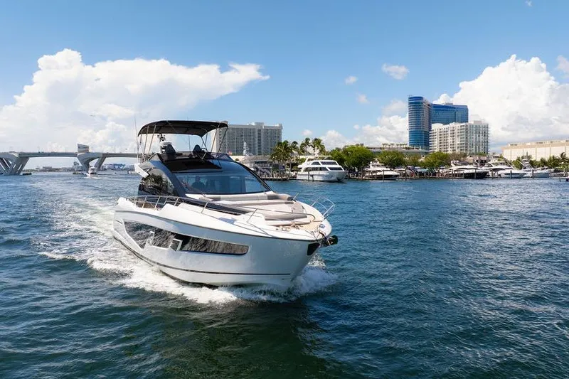  Yacht Photos Pics 2023 Sunseeker 65 Sport Yacht cruising in a sunny marina setting.