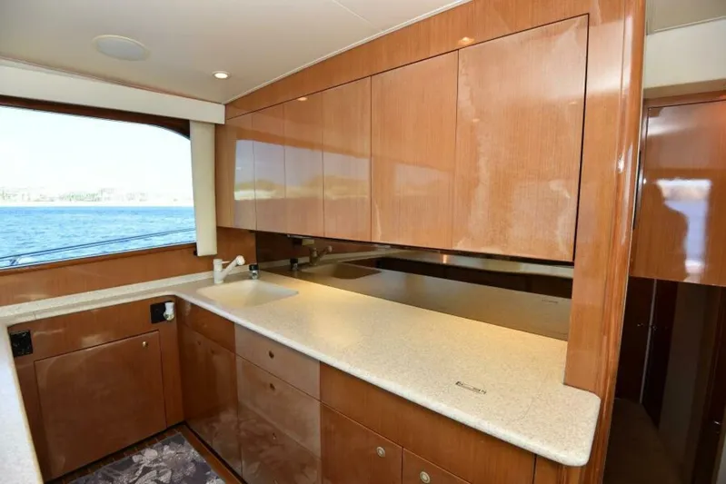 Happy Ending Yacht Photos Pics Luxurious kitchen interior of 2000 Viking 55 Convertible yacht with wooden cabinetry.