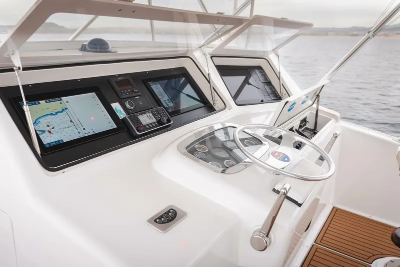 Happy Ending Yacht Photos Pics Helm of 2000 Viking 55 Convertible yacht with navigation screens and steering wheel.