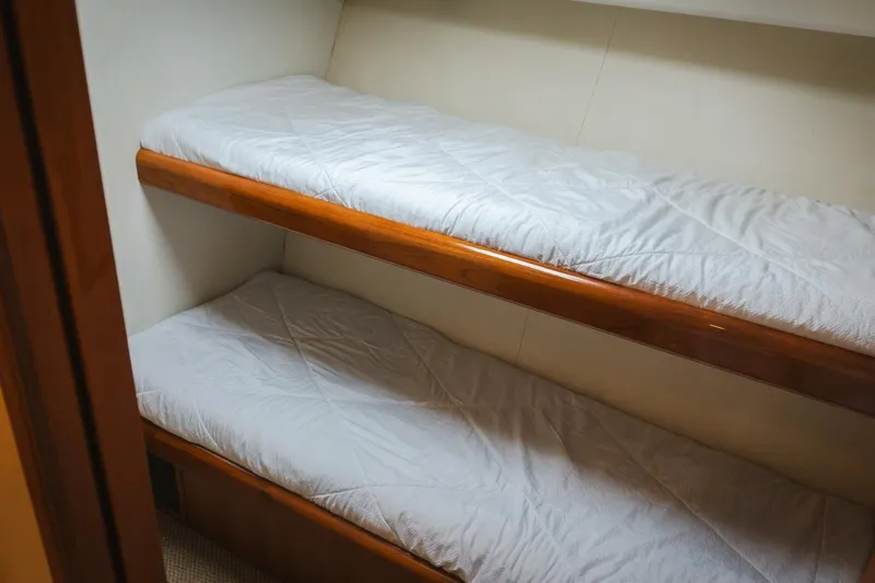 Happy Ending Yacht Photos Pics Bunk beds in 2000 Viking 55 Convertible yacht cabin, featuring wooden frames and white bedding.