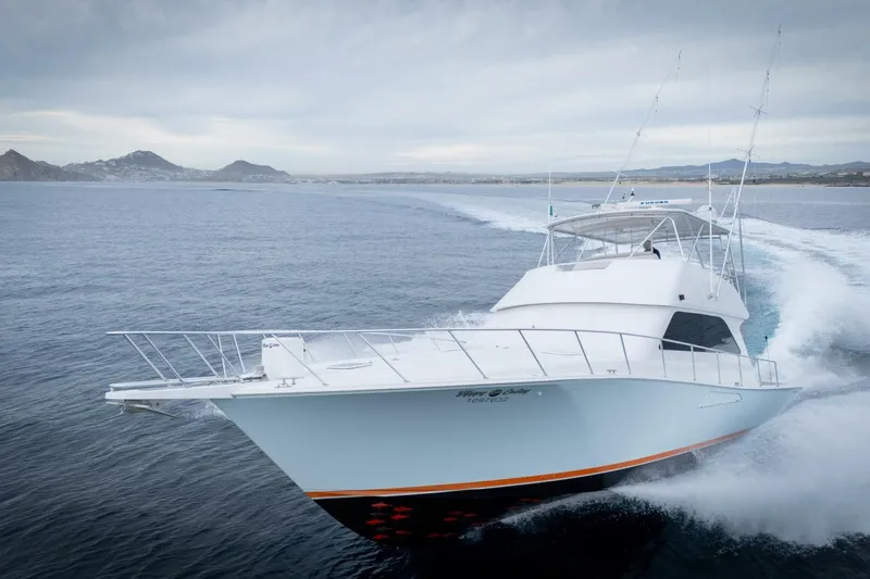 Happy Ending Yacht Photos Pics 2000 Viking 55 Convertible yacht cruising on open water with mountainous coastline in background.