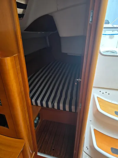 True Blue Yacht Photos Pics Cozy cabin interior of 2000 Beneteau First 40.7 sailboat with striped bedding.