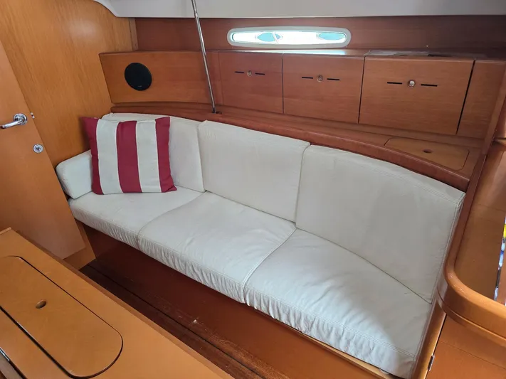 True Blue Yacht Photos Pics Interior of 2000 Beneteau First 40.7 yacht with white sofa and striped pillow.