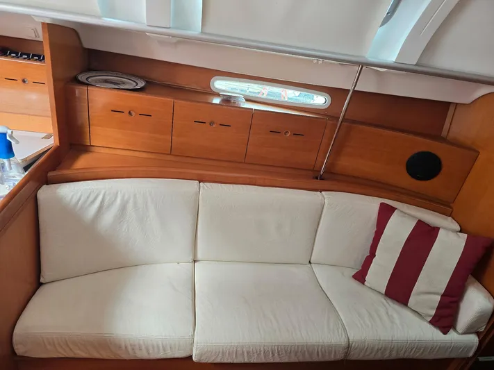True Blue Yacht Photos Pics Interior of 2000 Beneteau First 40.7 yacht with white sofa and striped pillow.