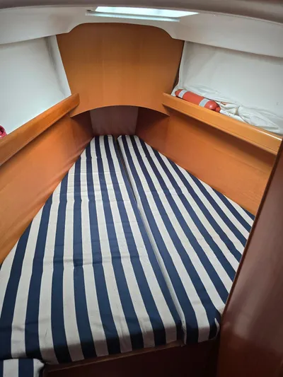 True Blue Yacht Photos Pics Beneteau First 40.7 2000 cabin with striped bedding and wooden interior.