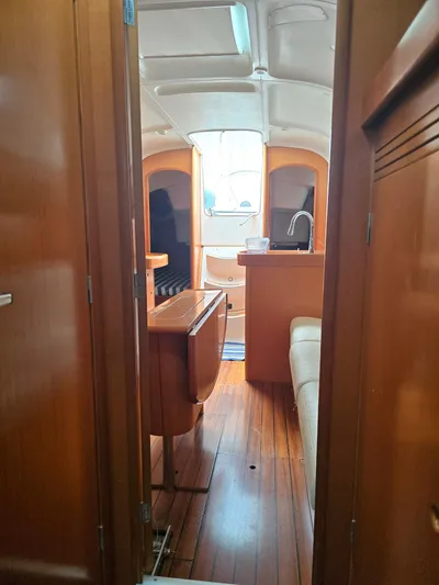 True Blue Yacht Photos Pics Interior of 2000 Beneteau First 40.7 sailboat, featuring wooden cabinetry and seating area.