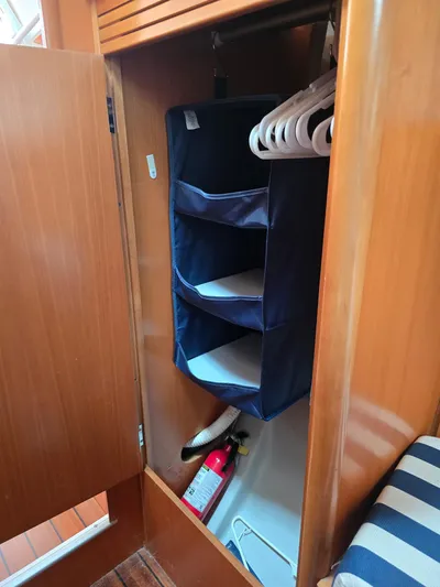 True Blue Yacht Photos Pics Wooden closet with hanging organizer and fire extinguisher in 2000 Beneteau First 40.7 sailboat.
