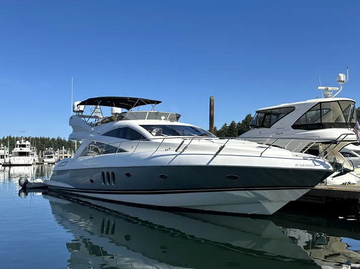 Lai Lani Yacht Photos Pics 2005 Sunseeker Manhattan 66 yacht docked in a marina under clear blue skies.