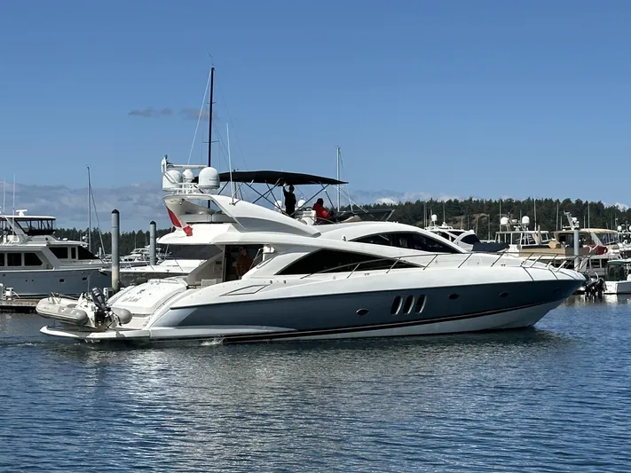 Lai Lani Yacht Photos Pics 2005 Sunseeker Manhattan 66 yacht cruising in a marina under clear blue skies.