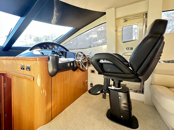 Lai Lani Yacht Photos Pics 2005 Sunseeker Manhattan 66 yacht helm with leather captain's chair and wooden dashboard.