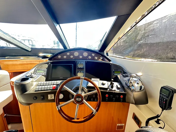 Lai Lani Yacht Photos Pics Cockpit of 2005 Sunseeker Manhattan 66 yacht with steering wheel and navigation controls.